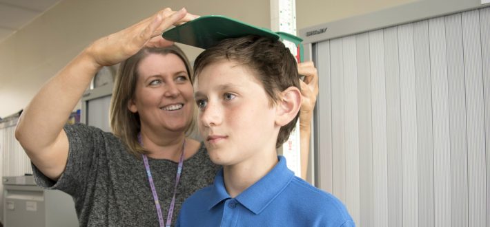 School nurse measures child