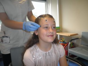 Brain activity monitoring leads on a child's head