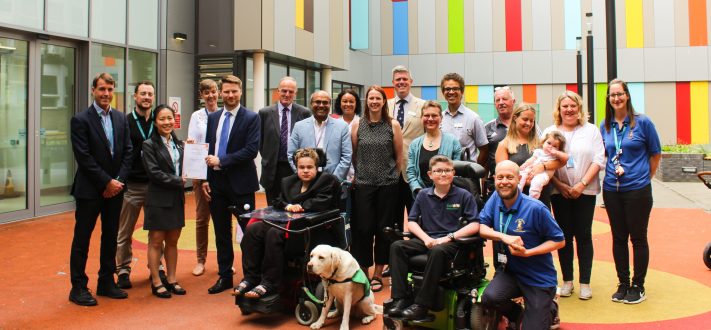 Patients and staff gather in the colourful courtyard to celebrate an award for the muscular dystrophy service
