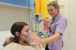 Lucy Mountain getting help from a nurse with her oxygen mask at Sheffield Childrens Hospital