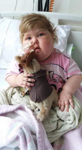 Young girl in hospital bed with toy recovering from leukaemia 