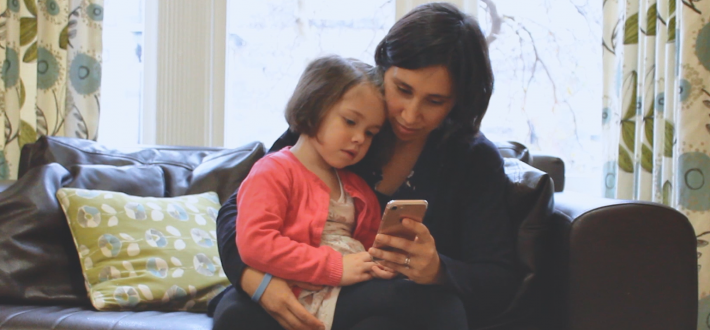 mum and daughter looking at app on phone