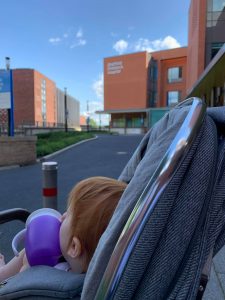 Child outside hospital in pram