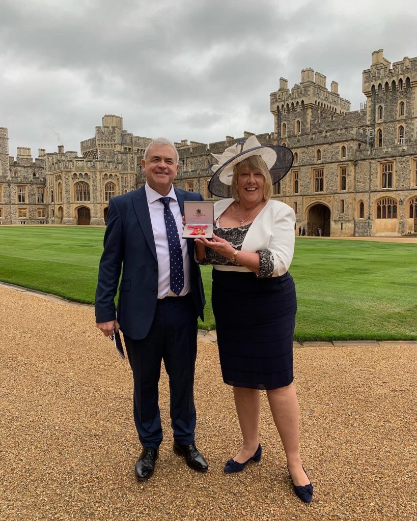 Sally Shearer posing at Windsor with her OBE medal