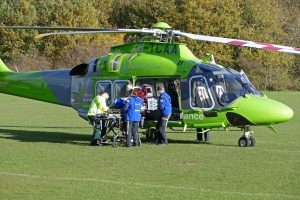 People taking a stretcher into a helicopter