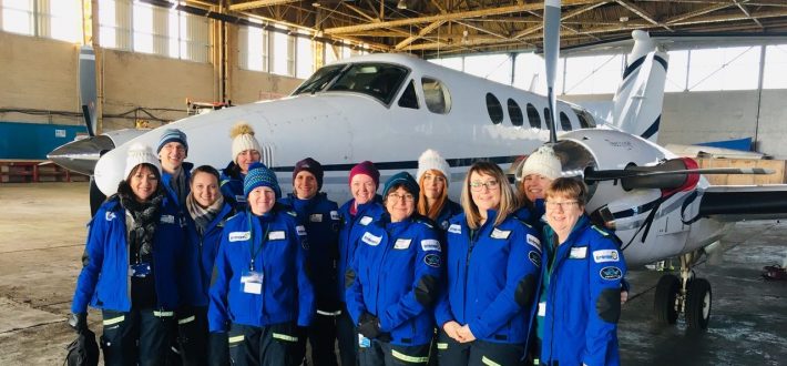Group of medical professionals stood in front of small plane