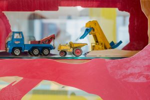blue truck with yellow digger and yellow lorry