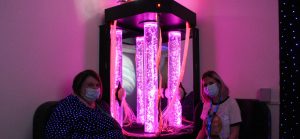 play team and nurse in sensory room with bright pink bubbly lights