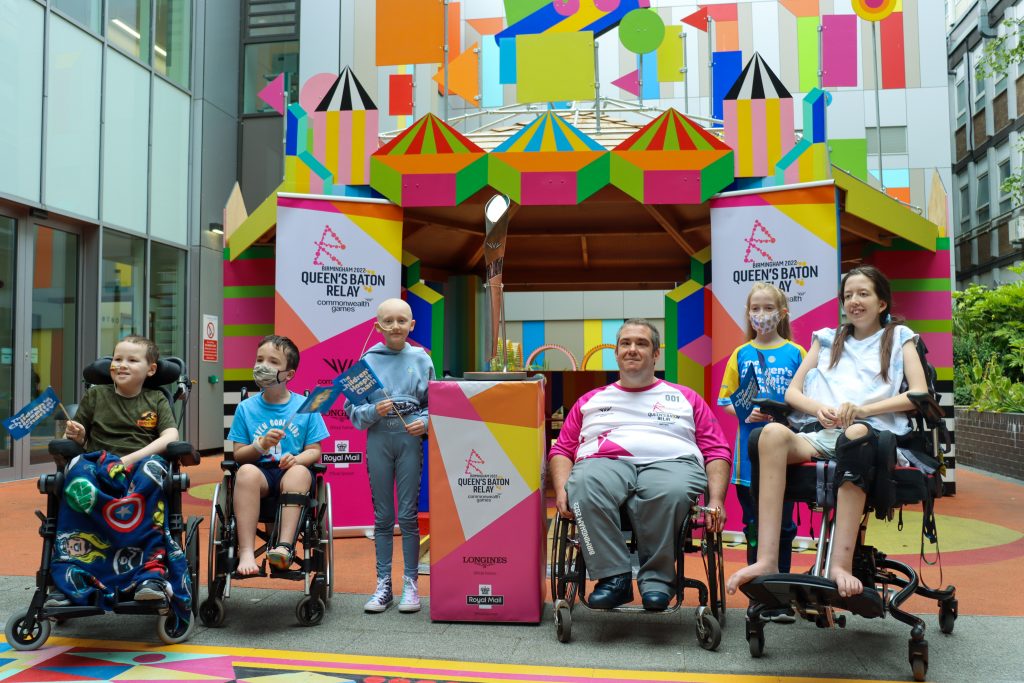 Patients and batonbearer outside joy garden with Queen's baton relay